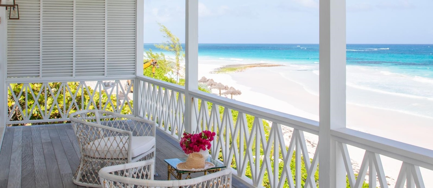 Balcony with comfy chairs, coffee table, flowers and sea view at Sea Siren in the Bahamas, Caribbean