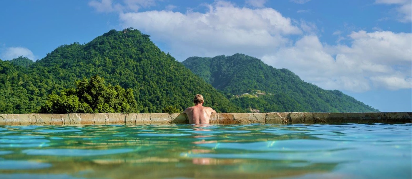 Guest enjoying mountain views from the infinity pool at Jungle Bay Dominica