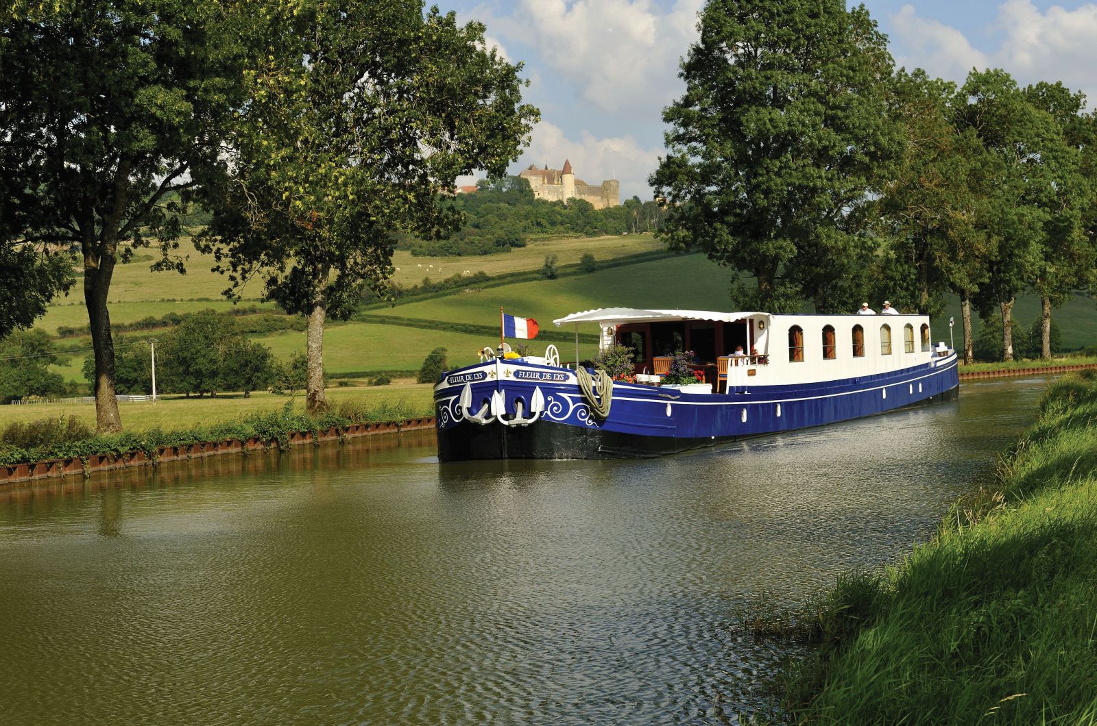 The Belmond Fleur de Lys river barge sailing through the French countryside