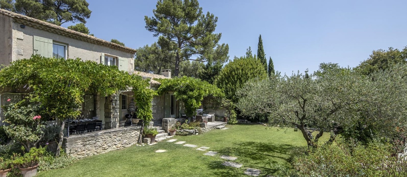 Façade and garden with trees, plants and flowers at Mas Cecile in Provence, France