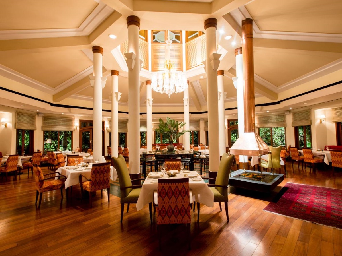 Comforting white table cloth dining area with eye catching chandelier in luxury hotel in India