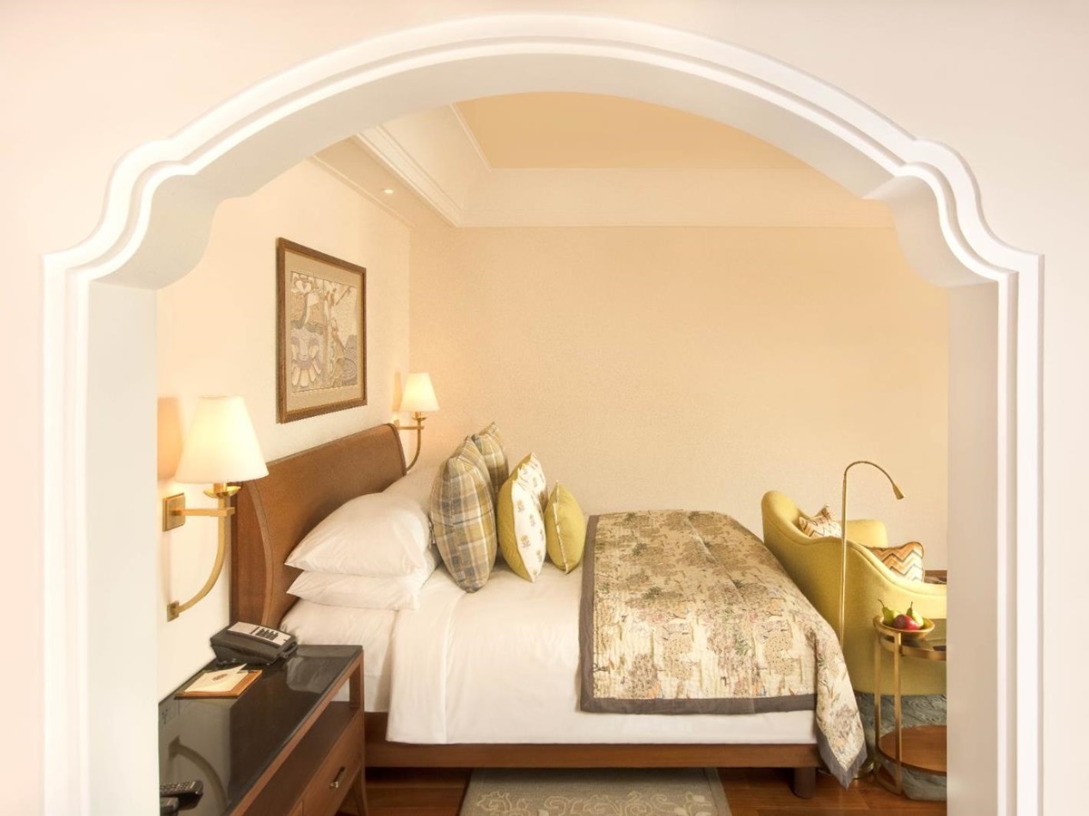 Guest room with king sized bed in bright bedroom in luxury hotel in India