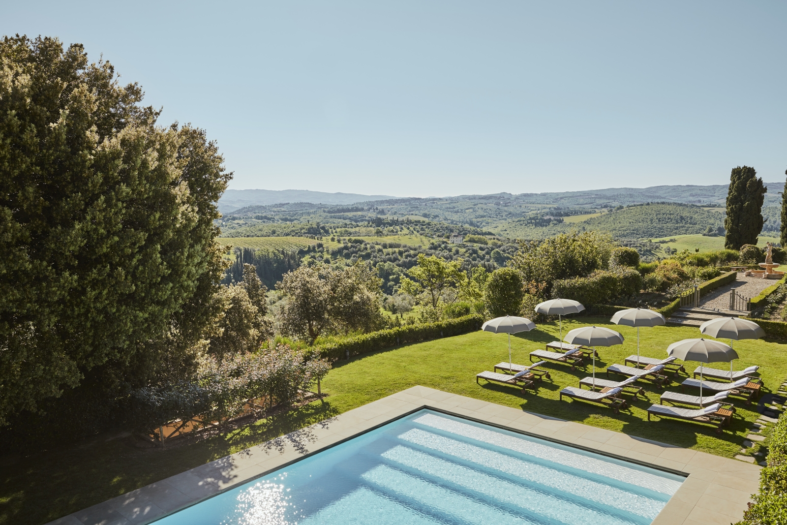 Pool and sun loungers at luxury resort COMO Castello del Nero in Italy