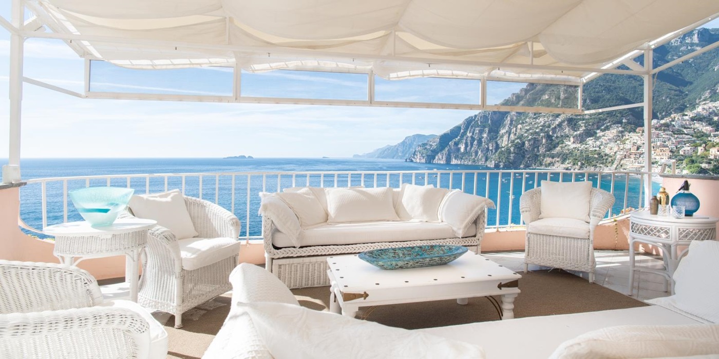 Outdoor seating with white furniture and white cover at Villa Contralto in Amalfi
