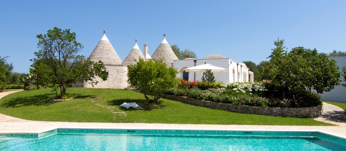 The swimming pool and facade of Trulli Lucia, luxury trulli in Puglia