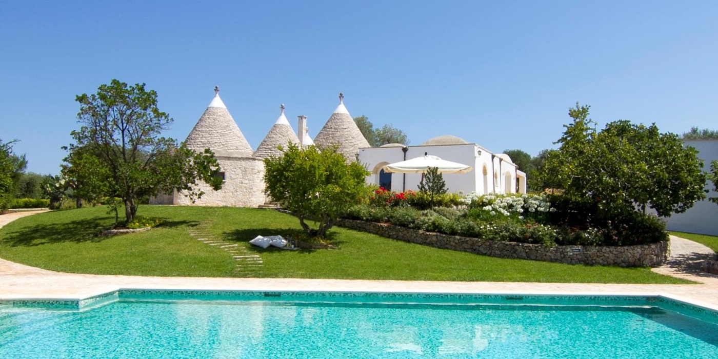 The swimming pool and facade of Trulli Lucia, luxury trulli in Puglia