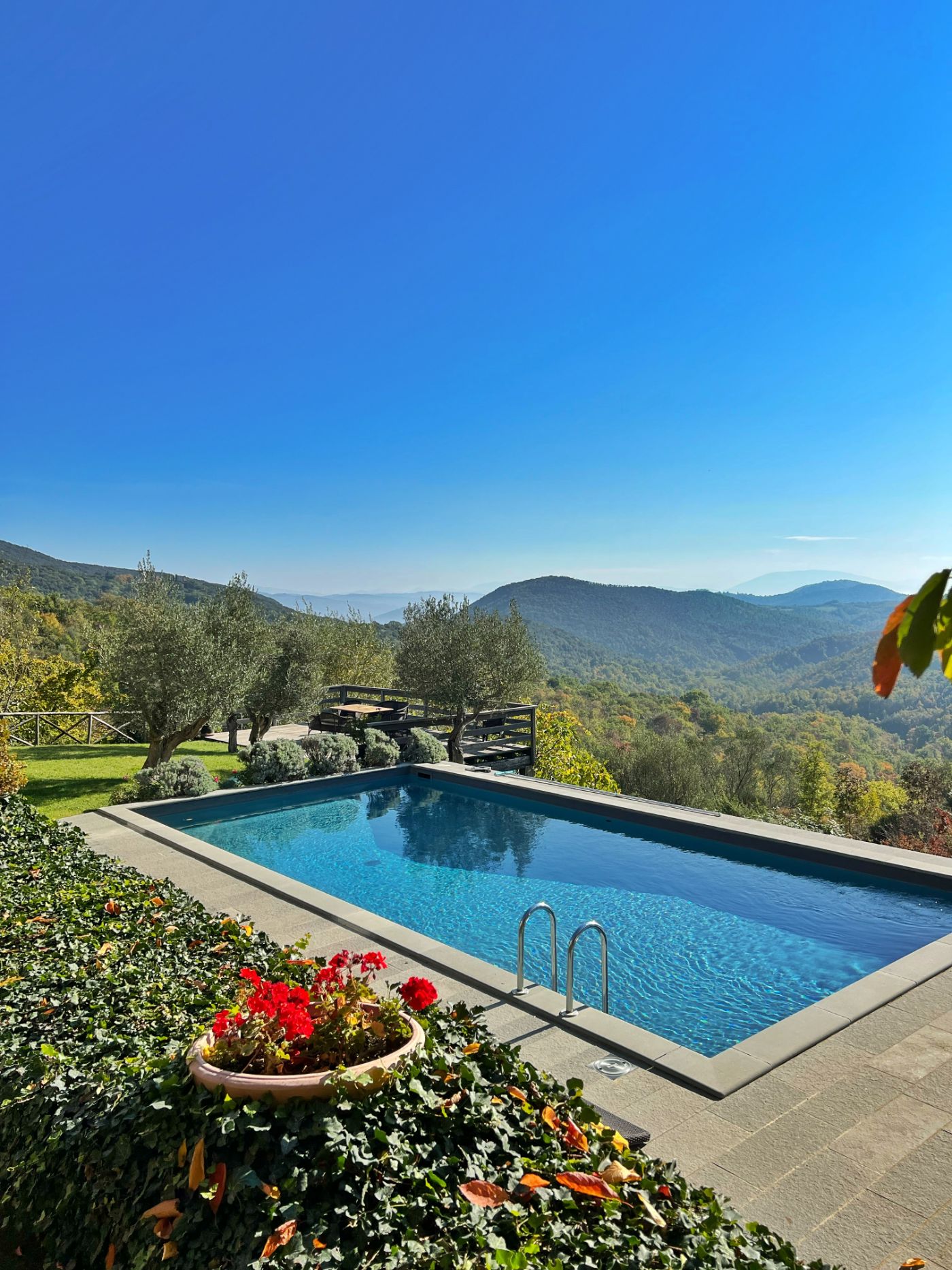 The pool on a sunny day overlooking hill views at Villa Pizzicato