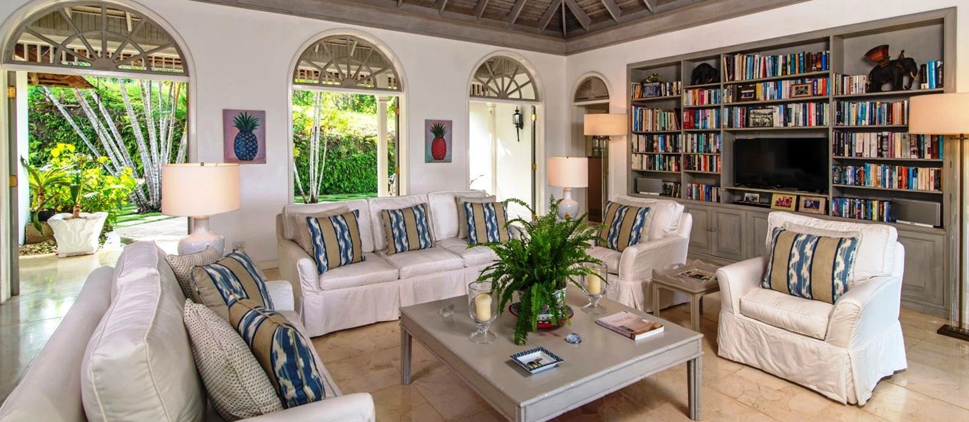 sitting area with white couches, coffee table and book shelves at Almond Hill Villa, Montego Bay Jamaica