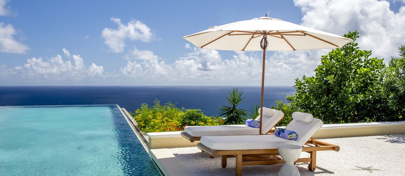 Sunbeds at the swimming pool of Ocean Breeze, Mustique