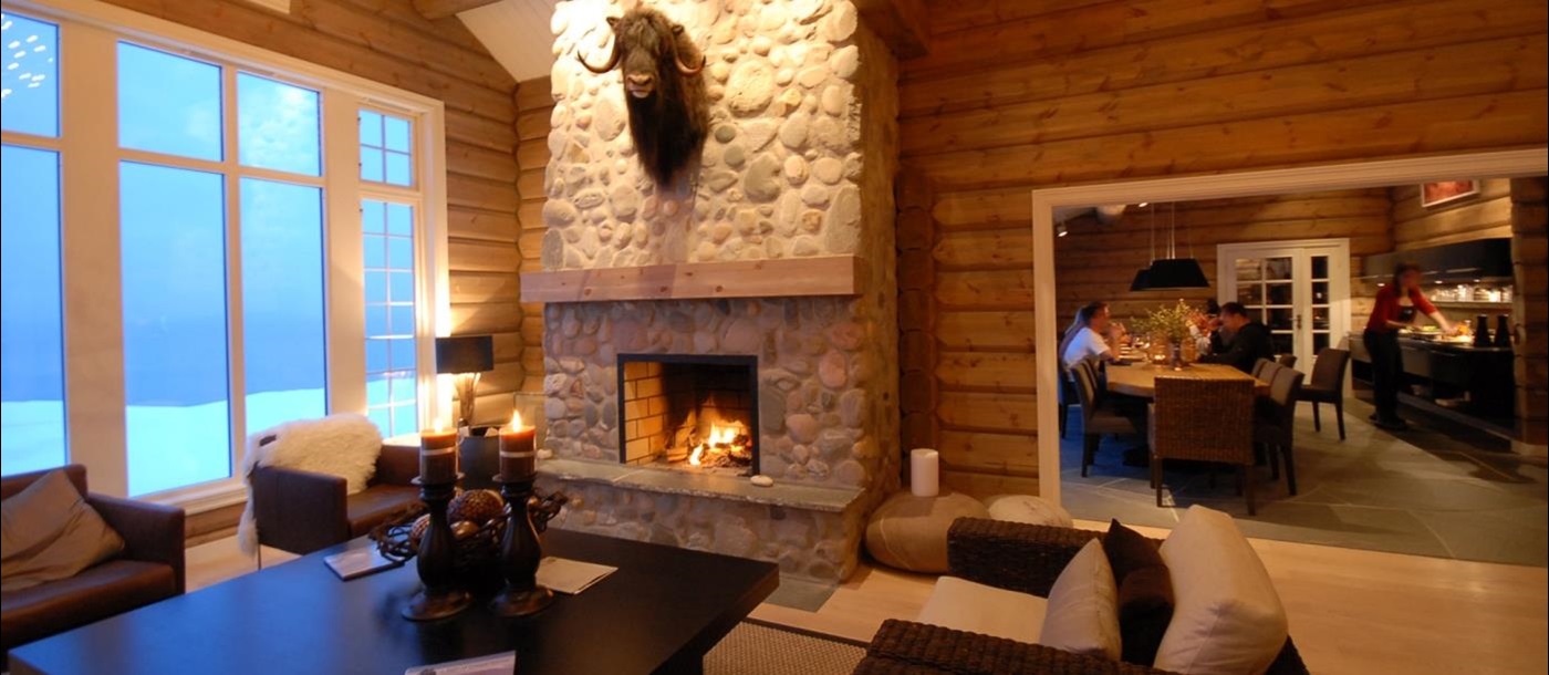 Cosy lounge area with fireplace at Lyngen Lodge in Norway