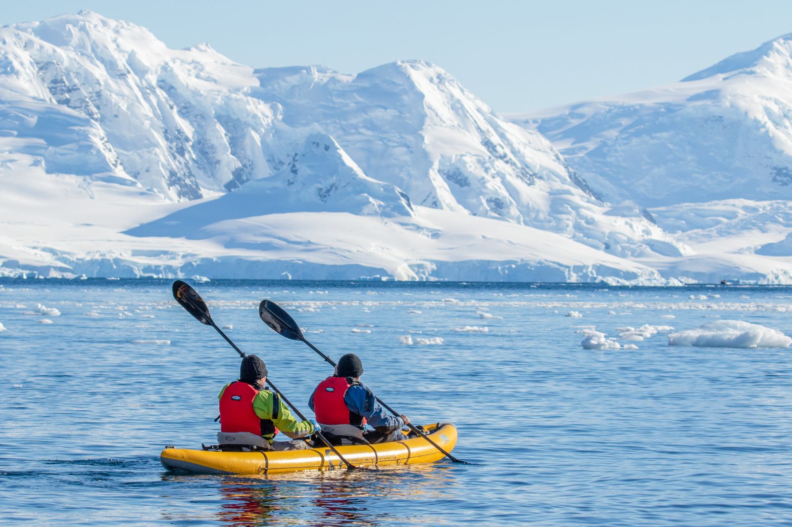 A couple kayaking in Antarctica