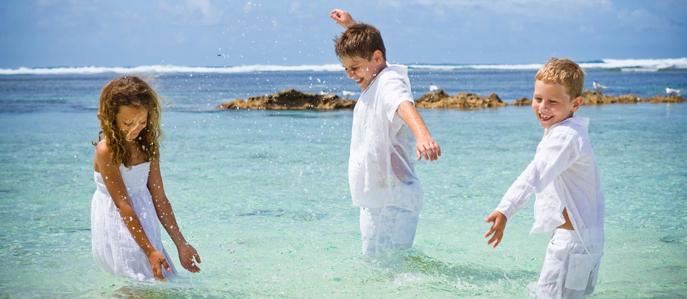 Children playing in the ocean at Denis Island, Seychelles