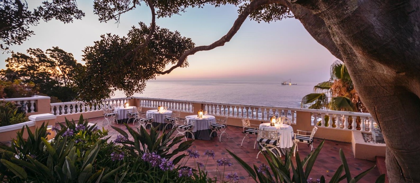 Sunset dining on the terrace of luxury hotel Ellerman House in Cape Town overlooking the sea