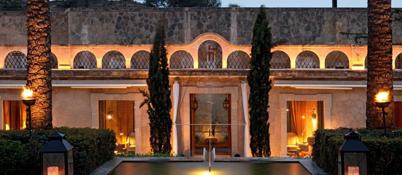 View over a fountain to the entrance of luxury resort Cap Rocat on Mallorca,Spain in the evening