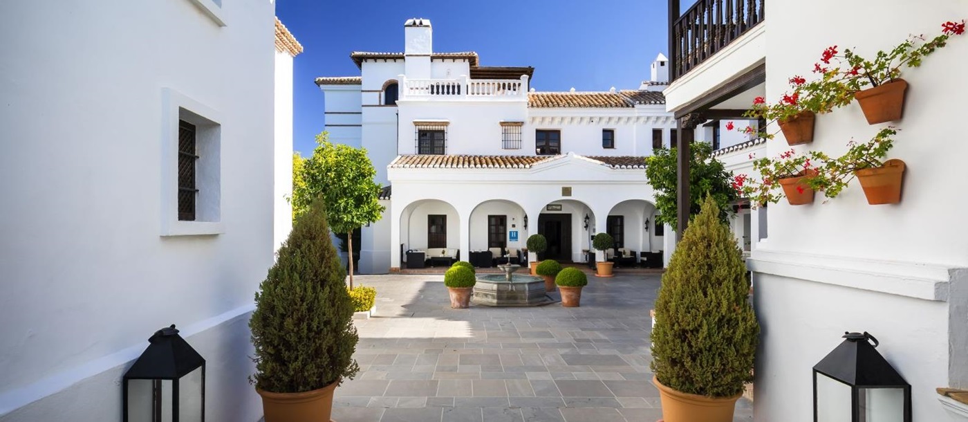 Courtyard lined by the white washed exterior of luxury resort La Bobadilla near Grenada, Spain