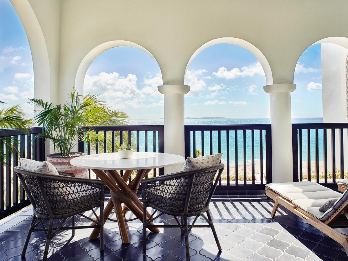 Balcony terrace with seating and views of the Caribbean Ocean from Belmond's Cap Juluca resort in Anguilla