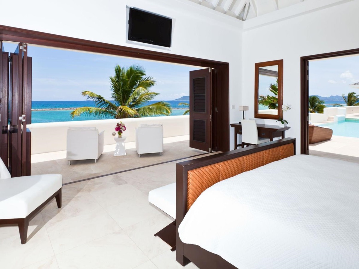 double bedroom with swimming pool and terrace access at le bleu, anguilla
