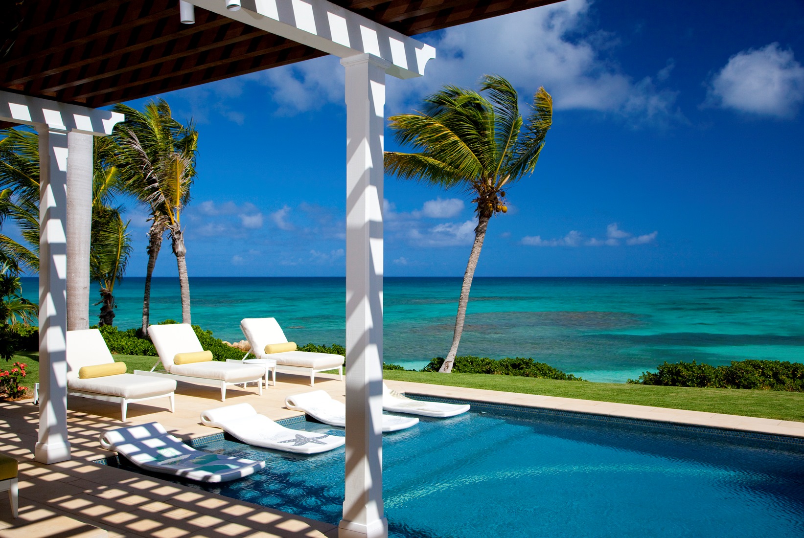 The swimming pool with ocean view at Frangipani, Antigua