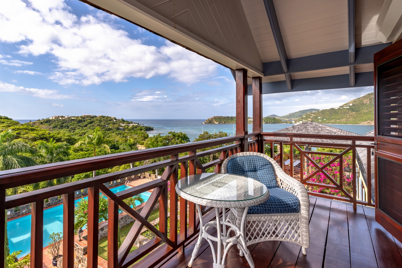 Balcony with comfy chair, table and sea view at St Anne’s Point in Antigua, the Caribbean