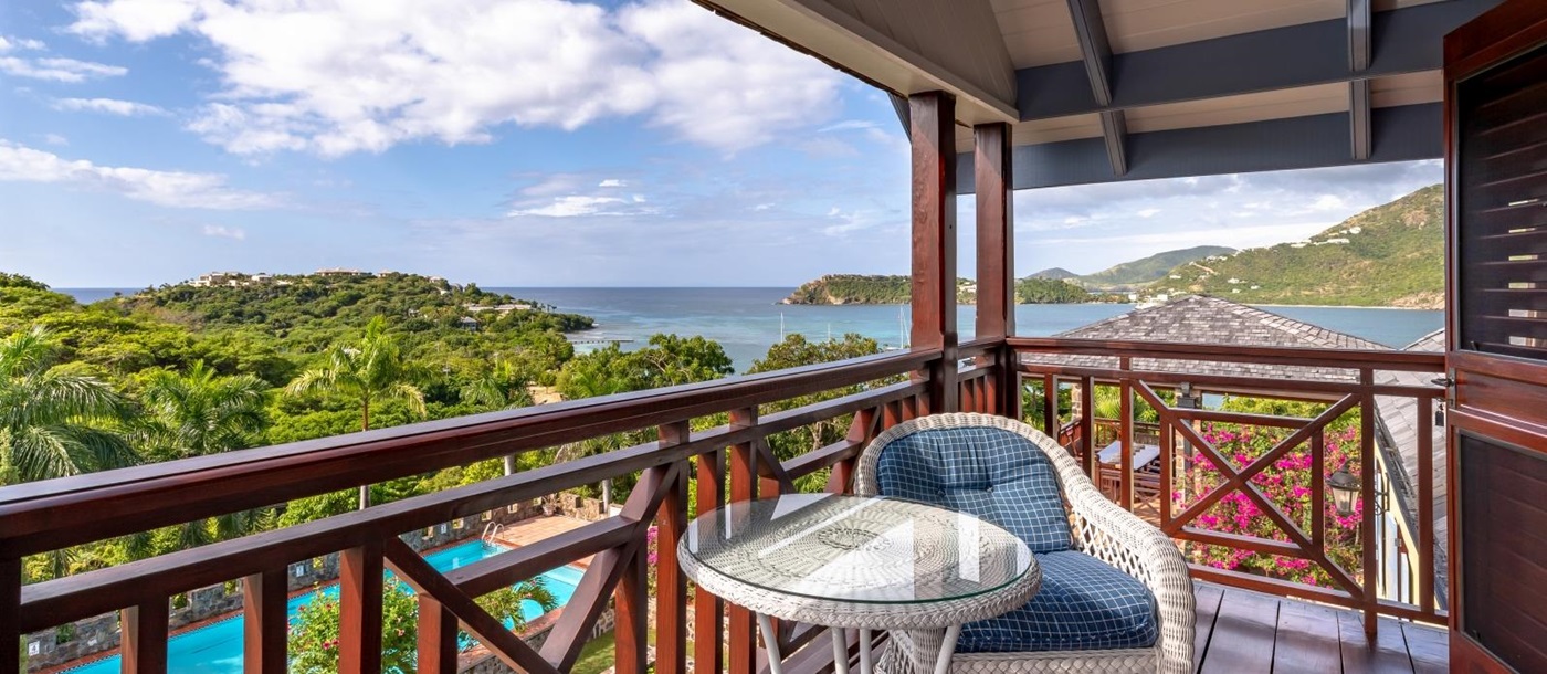 Balcony with comfy chair, table and sea view at St Anne’s Point in Antigua, the Caribbean