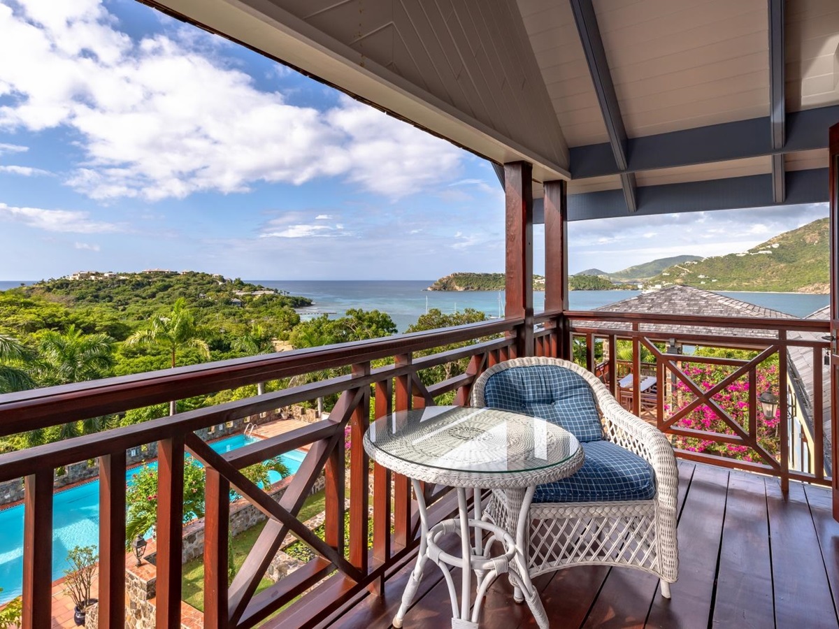 Balcony with comfy chair, table and sea view at St Anne’s Point in Antigua, the Caribbean