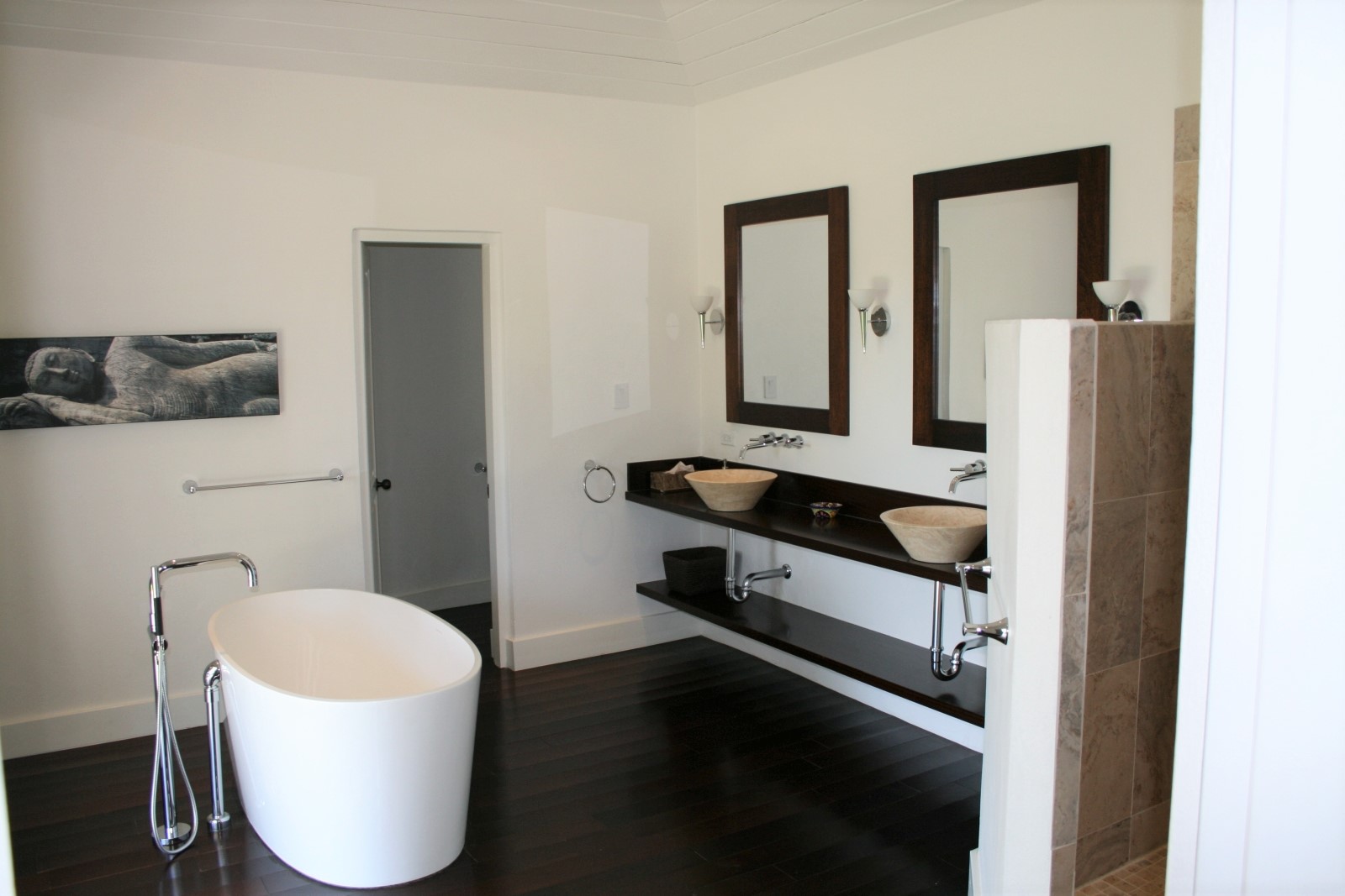 Bathroom with bath, double sinks, mirrors and artwork at The Hill Club in Antigua, the Caribbean