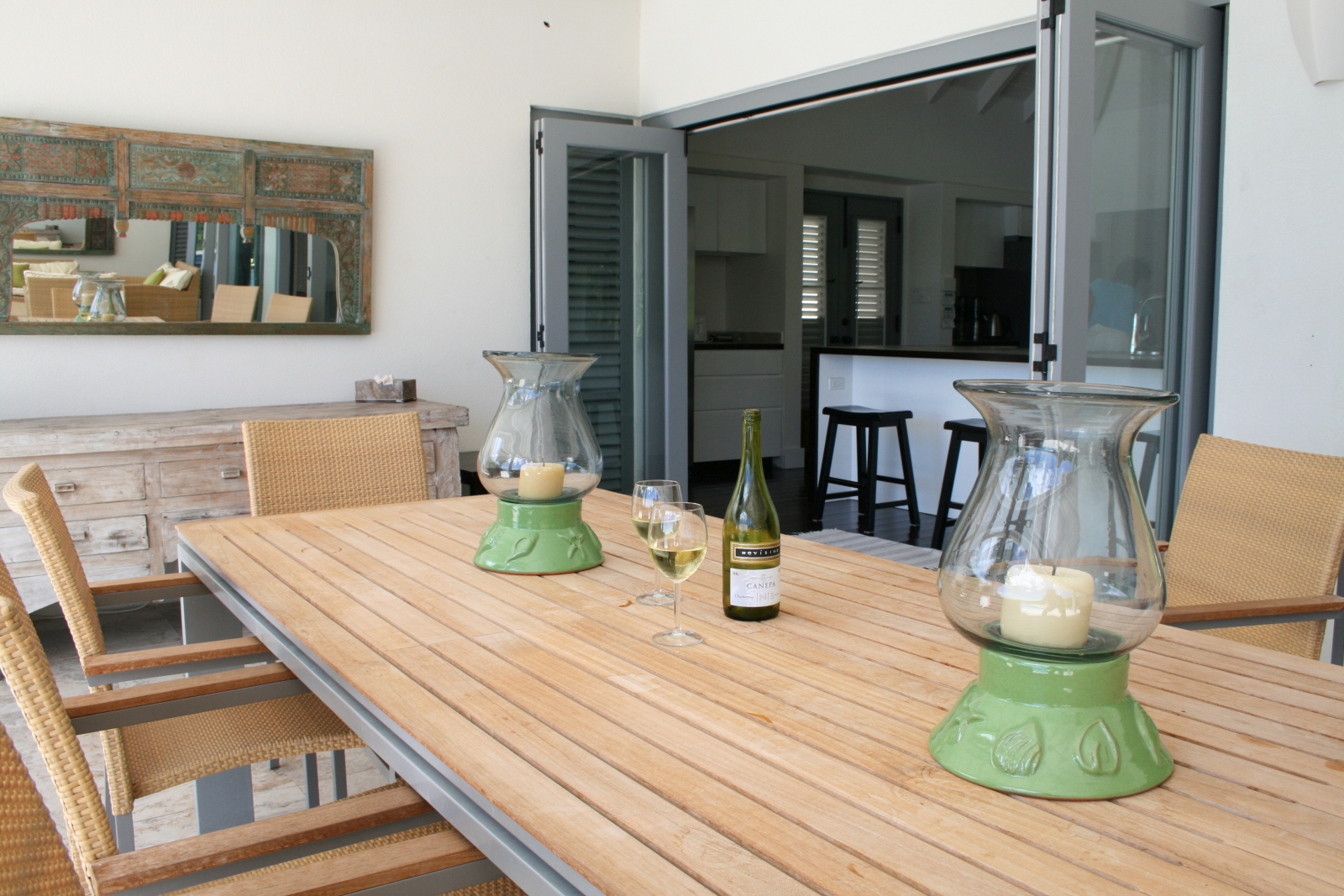 Outdoor dining area with dining table, chairs, wine and candles at The Hill Club in Antigua, the Caribbean