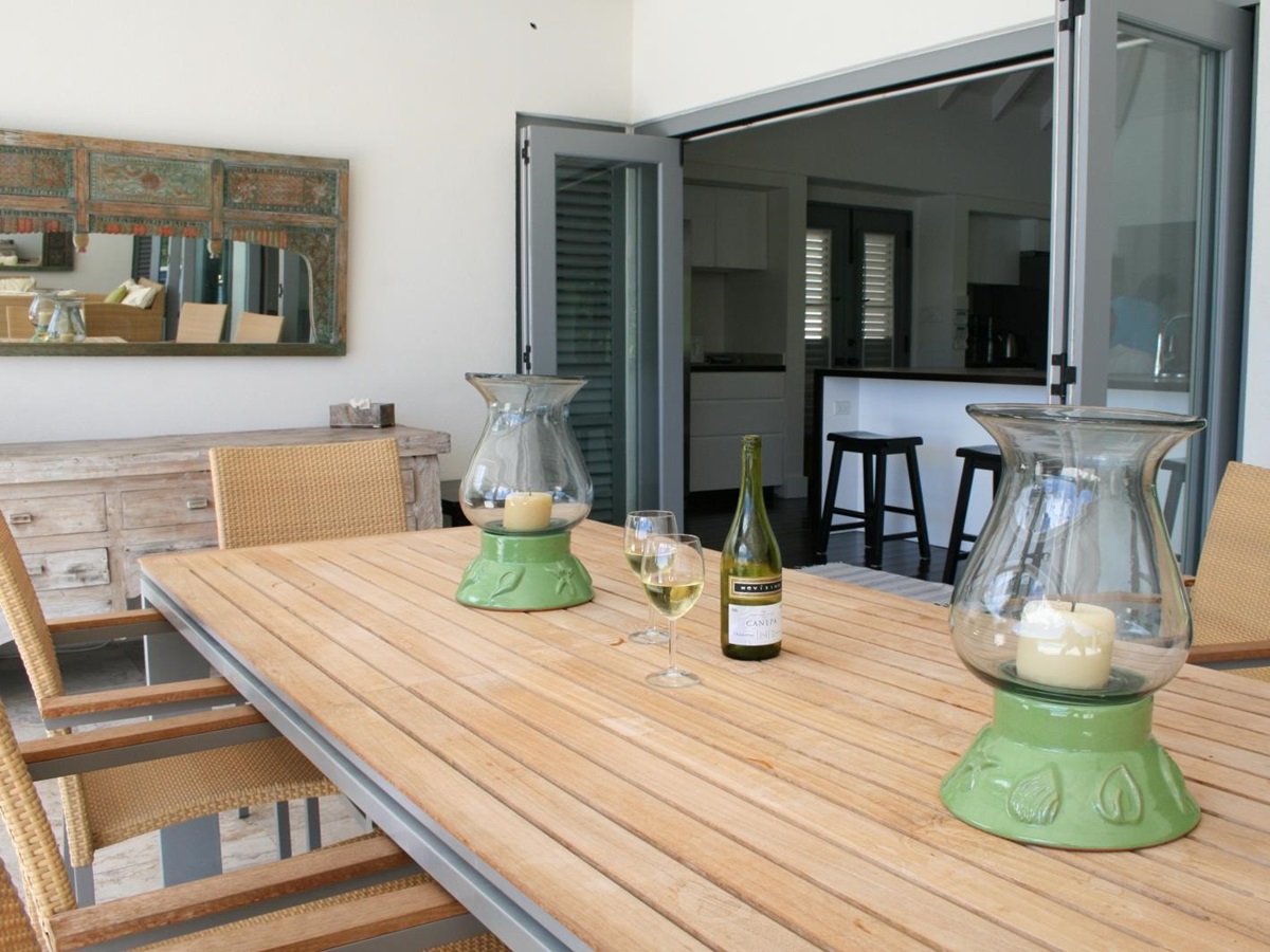 Outdoor dining area with dining table, chairs, wine and candles at The Hill Club in Antigua, the Caribbean