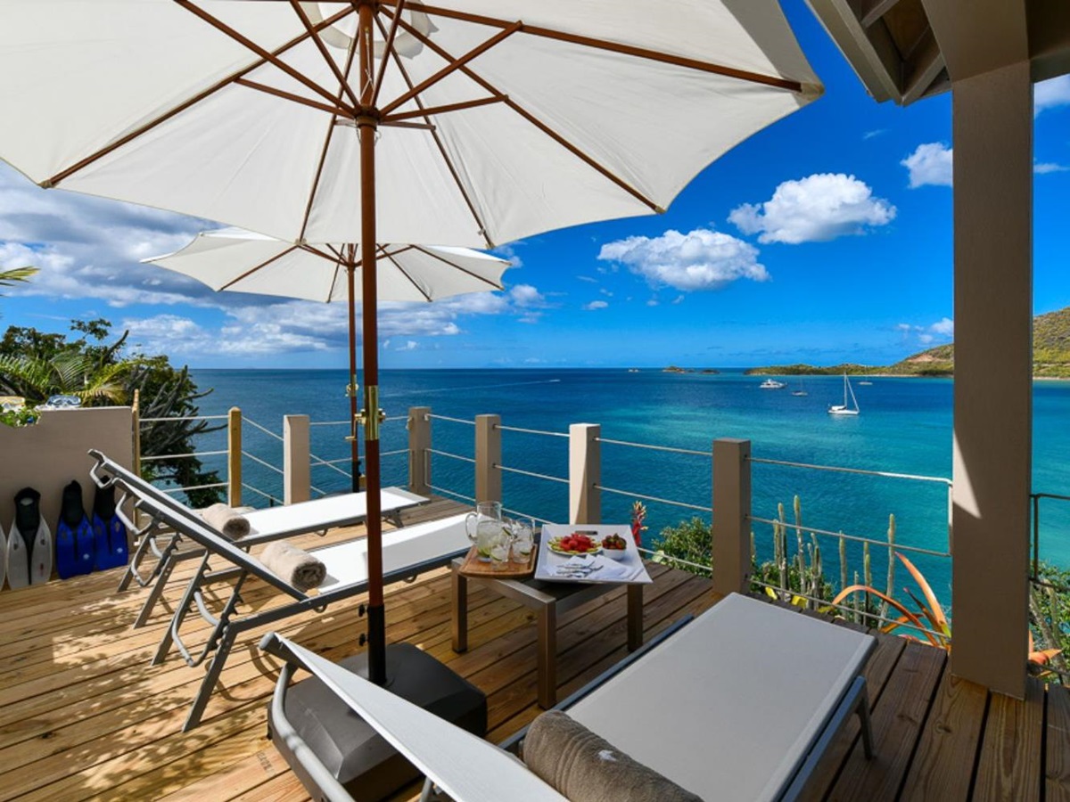 Terrace with loungers and sea view at Villa Papillon