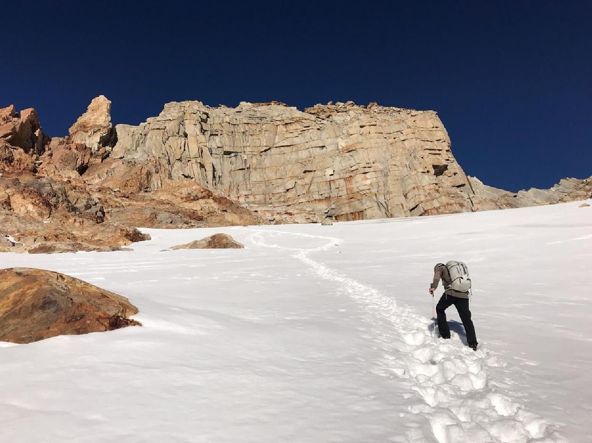 Guest hiking a snowcapped peak on an excursion from Explora El Chalten in Argentina