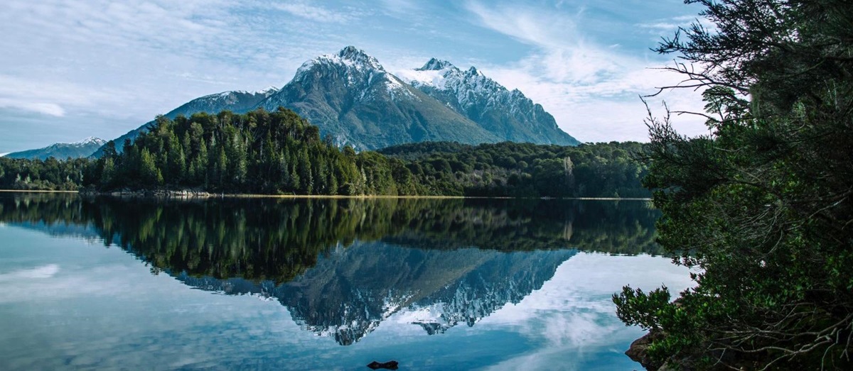 Snow-peaked mountain reflected in a glassy lake