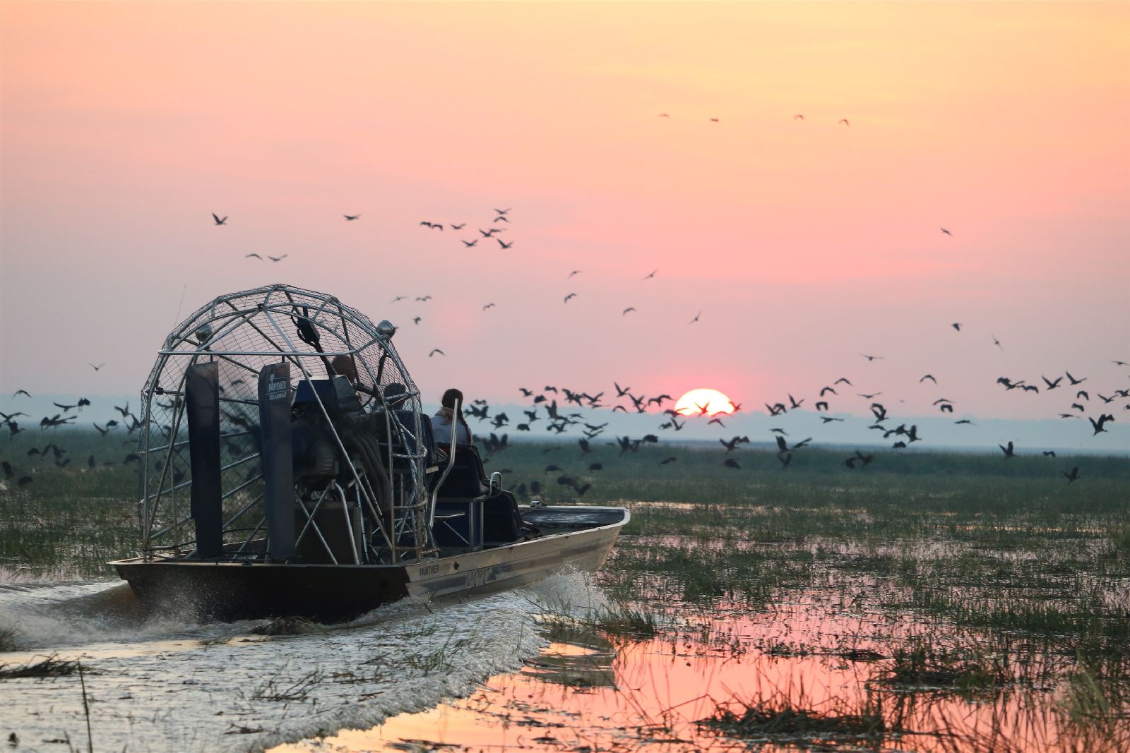 Guests enjoying a hoverboat ride at sunset from Bamurru Plains in Northern Australia