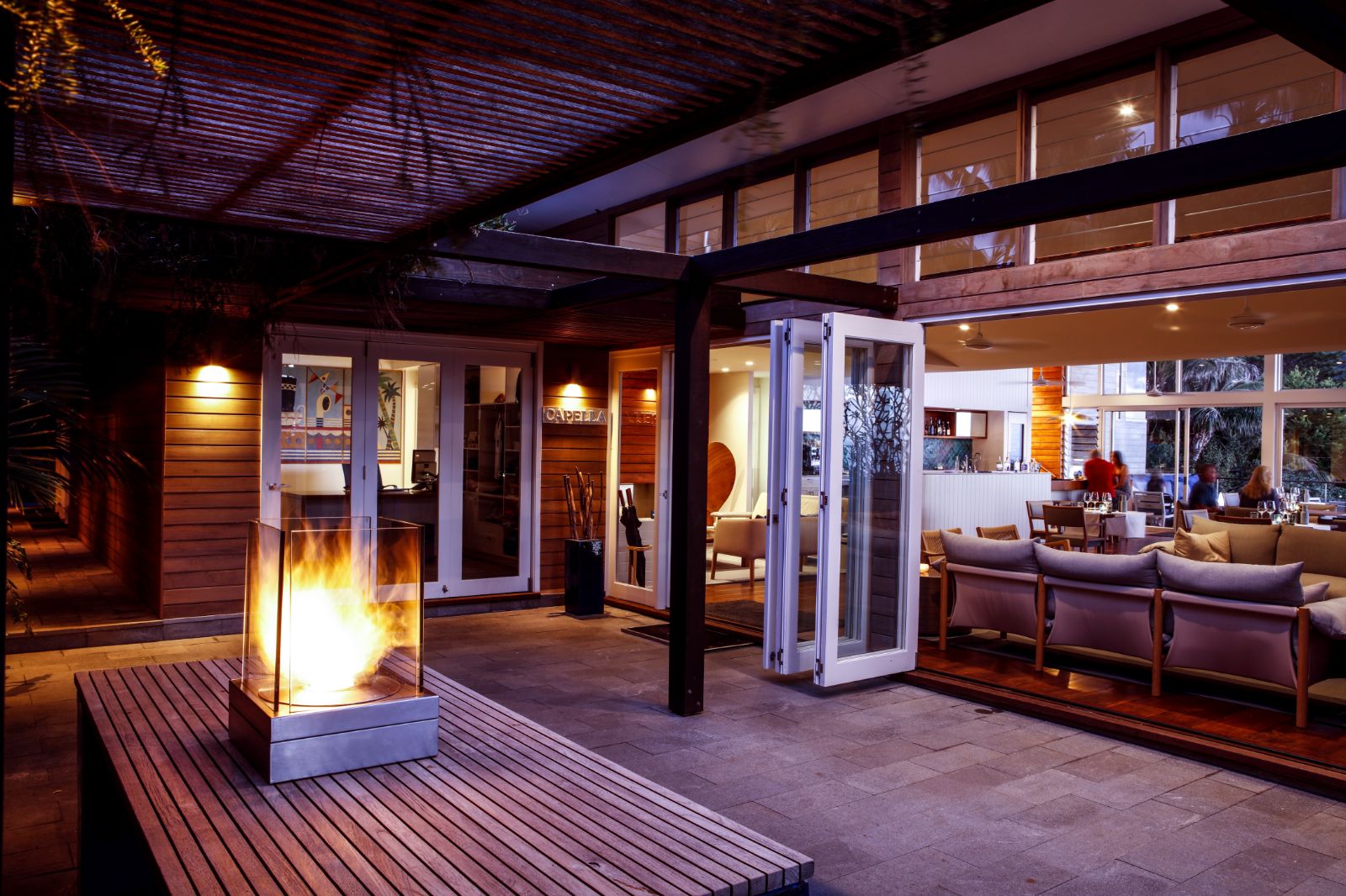 main lodge area with glowing fireplace and sofas to socialise in luxury Capella Lodge in Australia