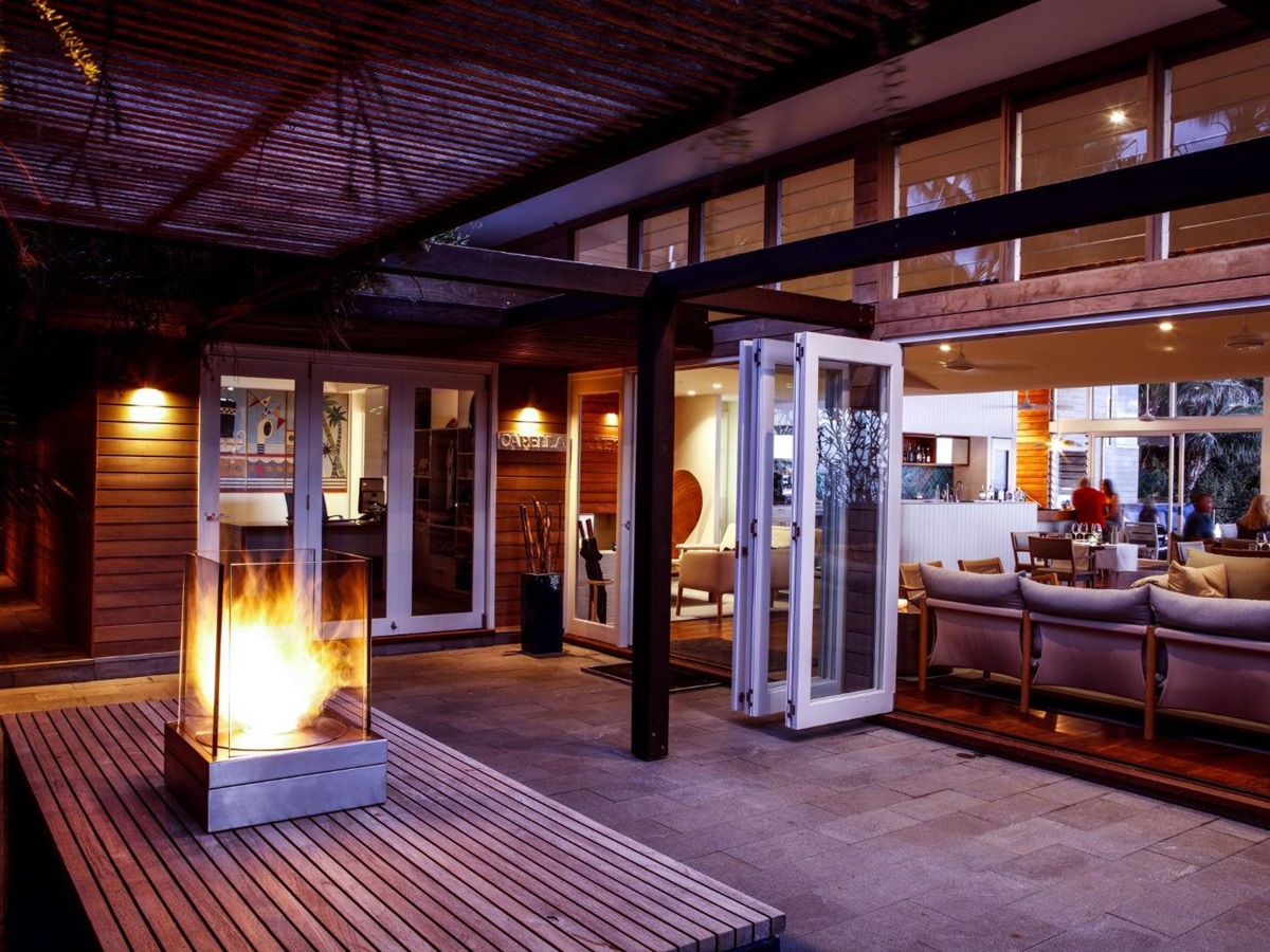 main lodge area with glowing fireplace and sofas to socialise in luxury Capella Lodge in Australia