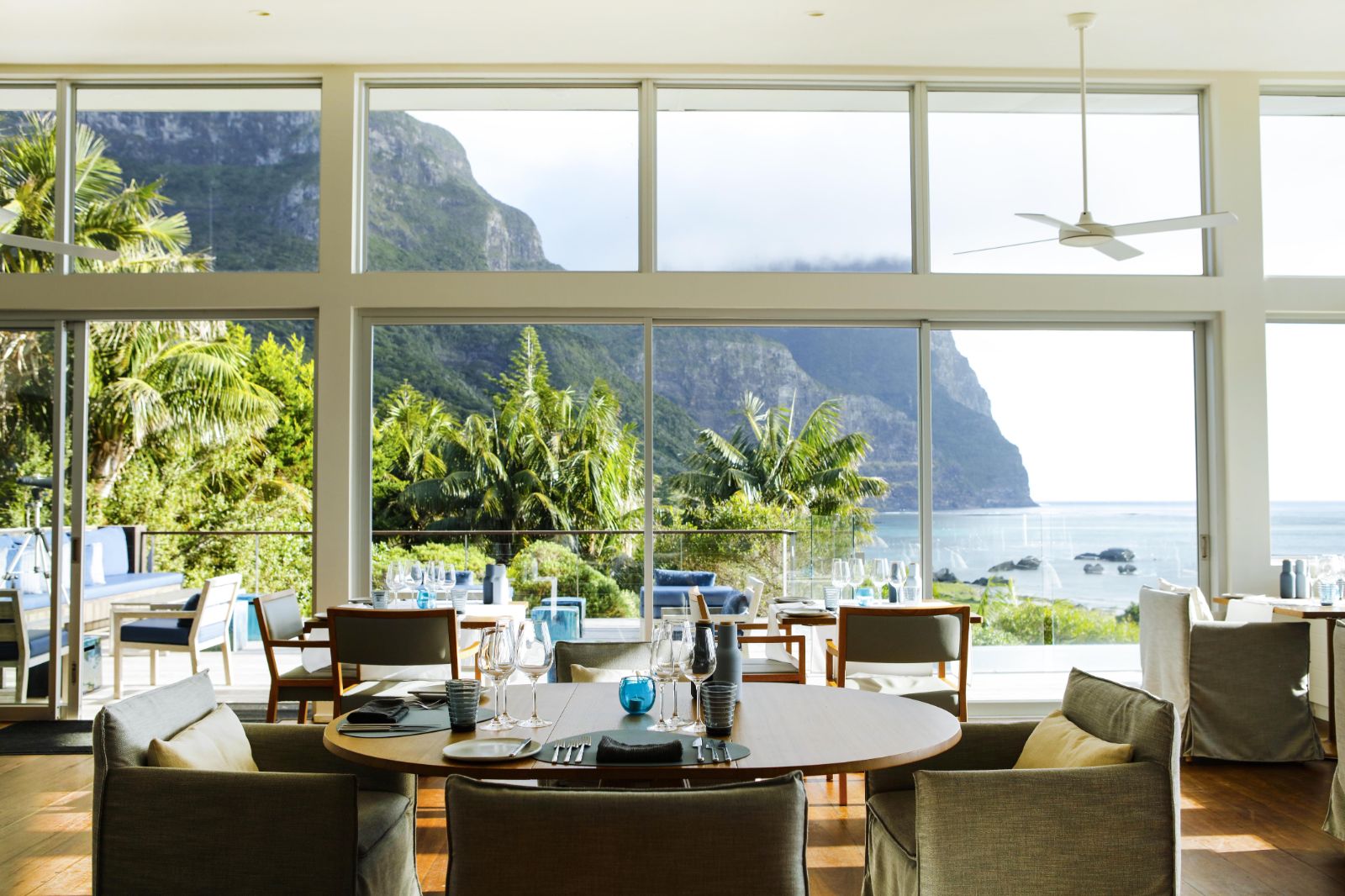 bright and sophisticated dining area with floor to ceiling windows looking out onto Lord Howe Island and clear blue seas in luxury Capella Lodge in Australia