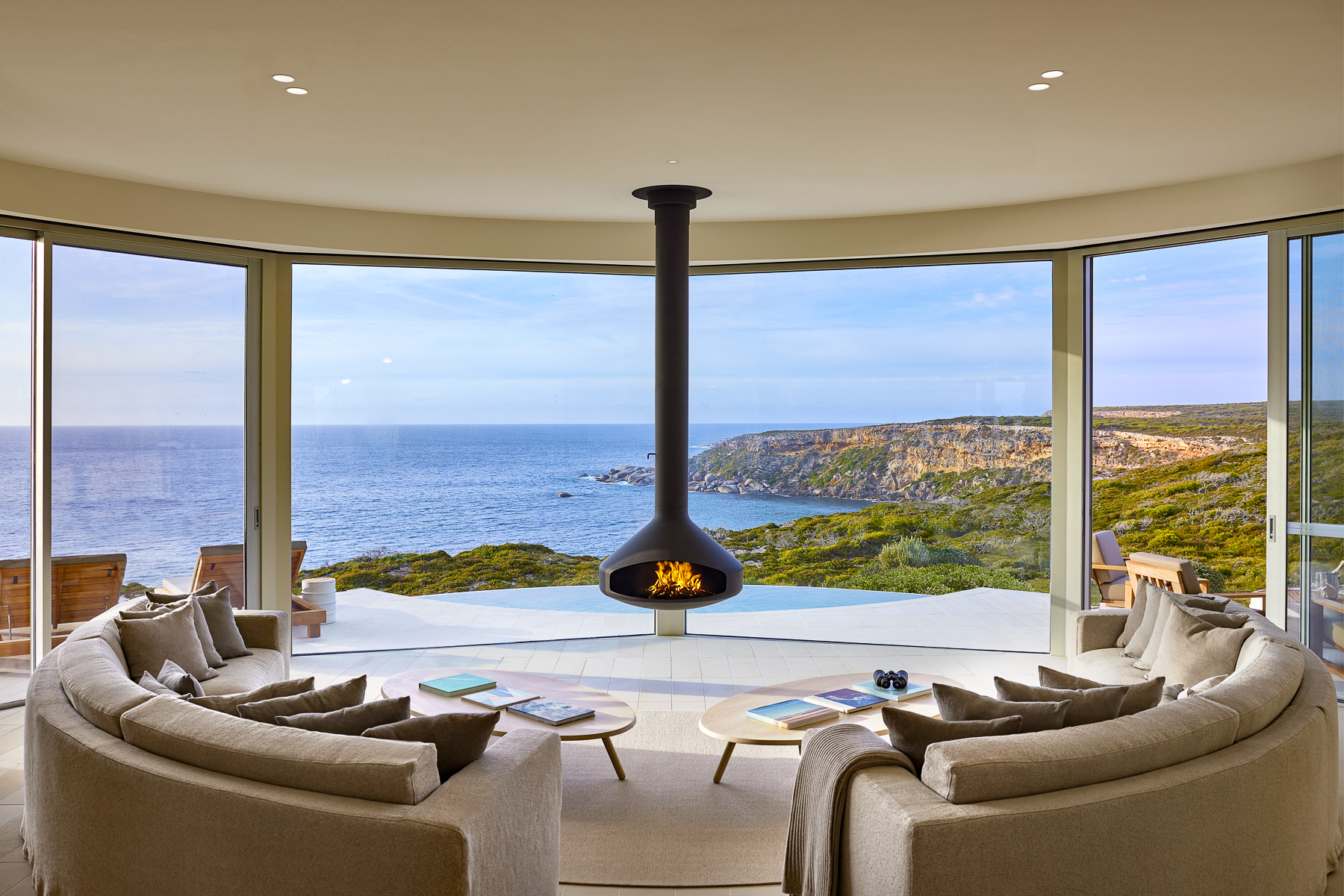 West lounge with fireplace and sea views at Southern Ocean Lodge