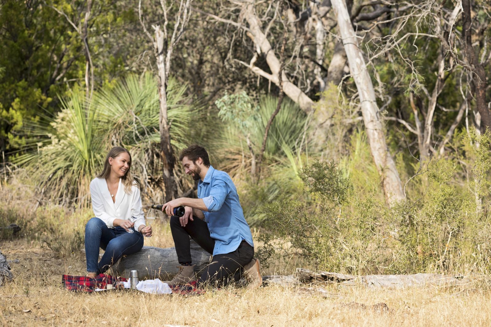 Young couple enjoying an outdoor picnic with prosecco