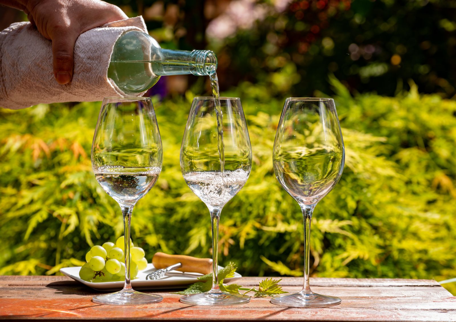 Glasses of white wine being poured in a vineyard setting in Australia