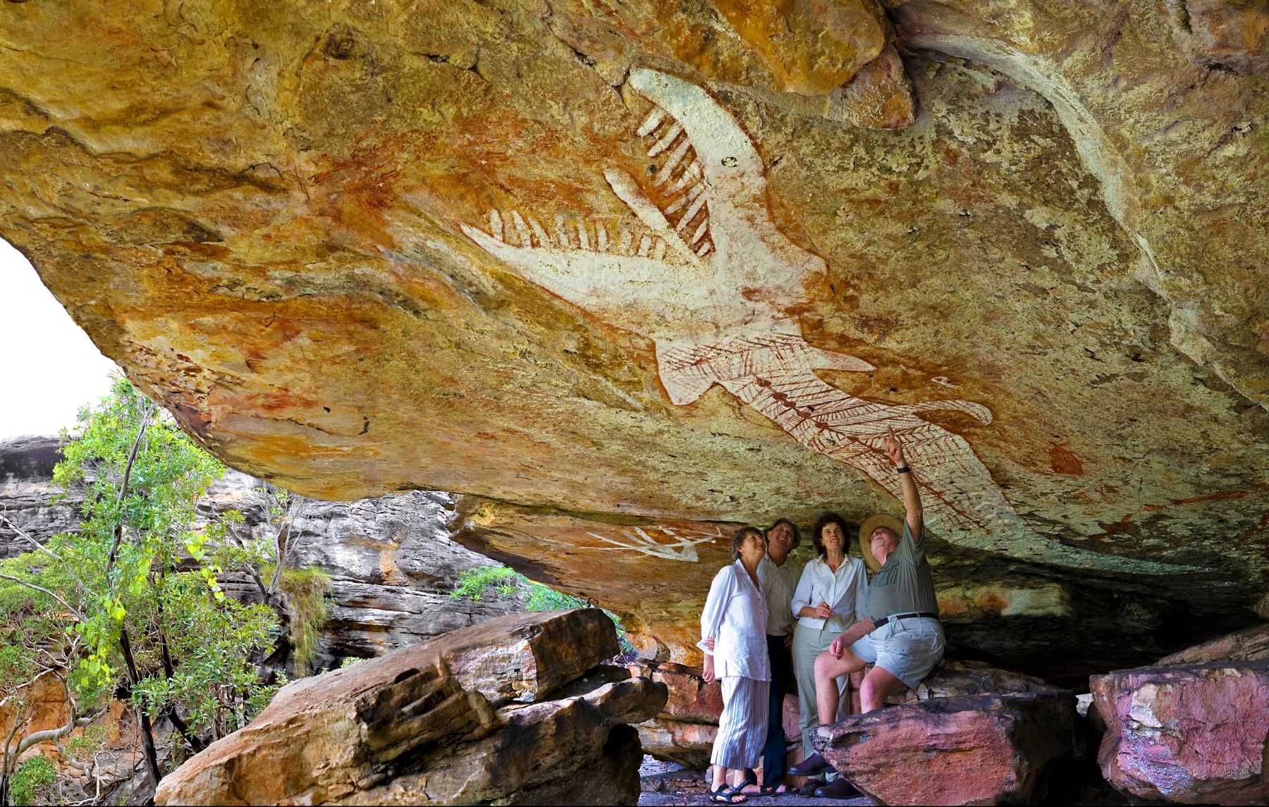 Visitors to Mt Borradaile in Arnhem Land, Australia looking at rock art with a guide