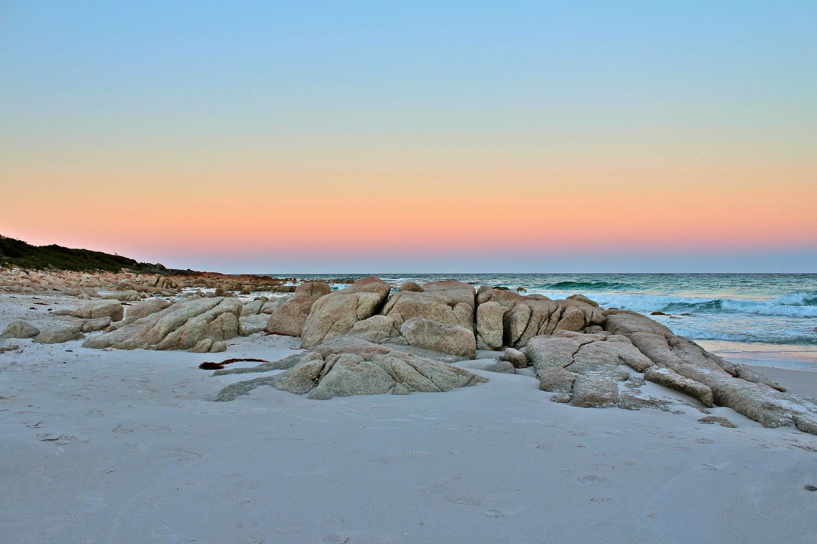 Rocky white sandy beach in Tasmania during sunset, Australia