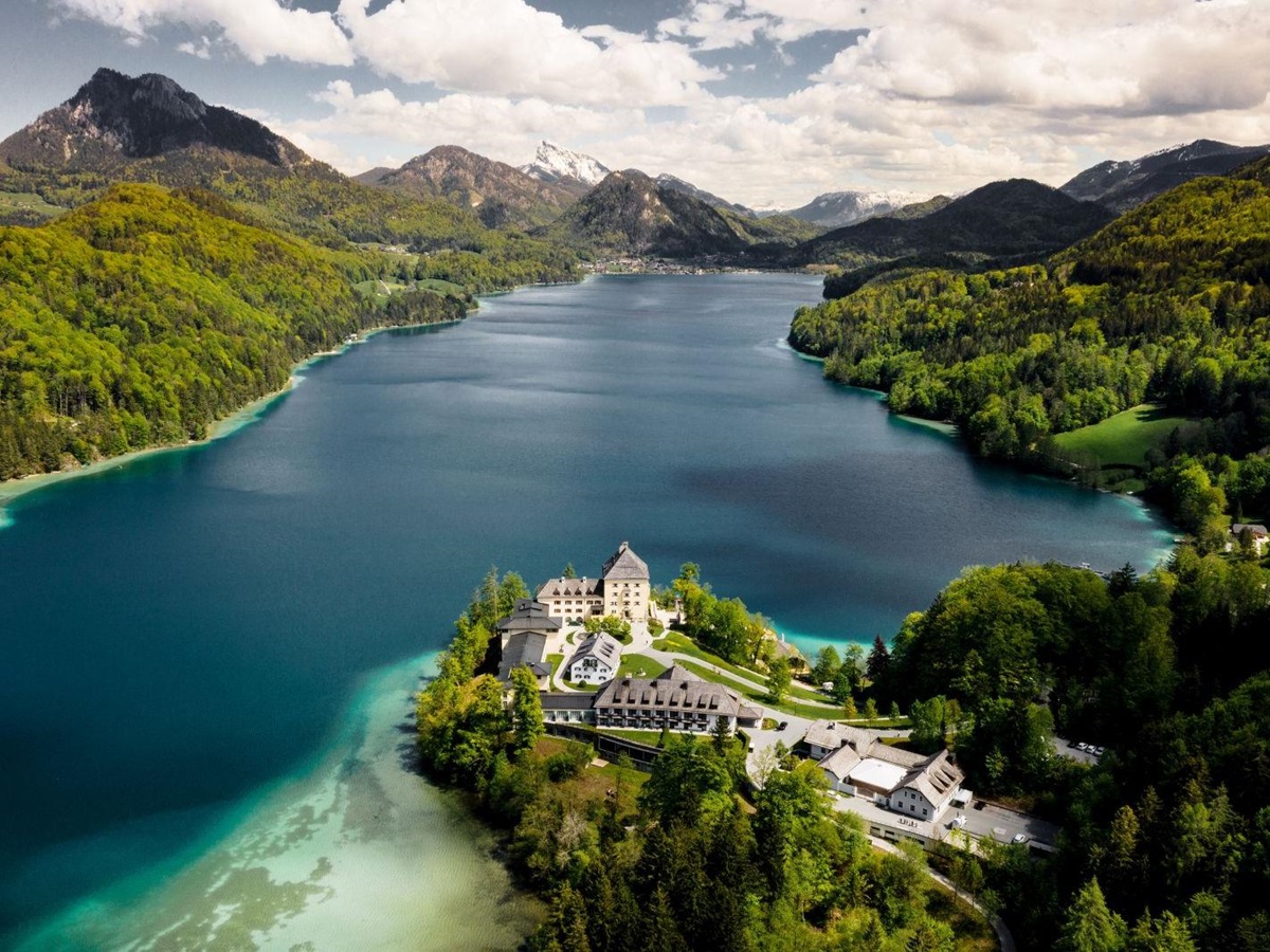 View of the Schloss Fuschl hotel in Austria with backdrop of lake and mountains