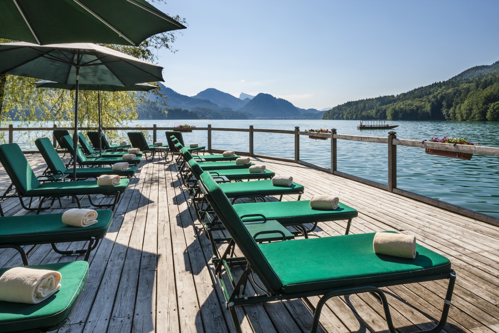 Sun deck with loungers and parasols at luxury hotel Schluss Fuschl in Austria