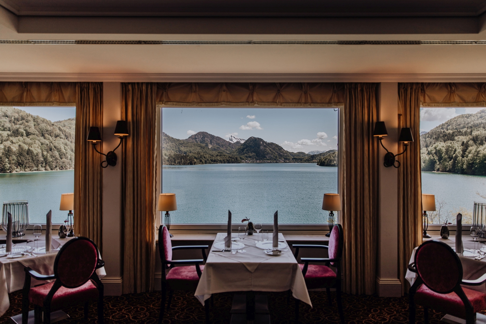 Tables in front of a window overlooking the lake at luxury hotel Schluss Fuschl in Austria