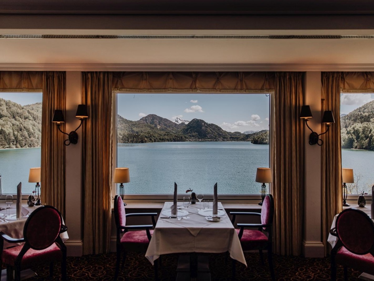 Tables in front of a window overlooking the lake at luxury hotel Schluss Fuschl in Austria