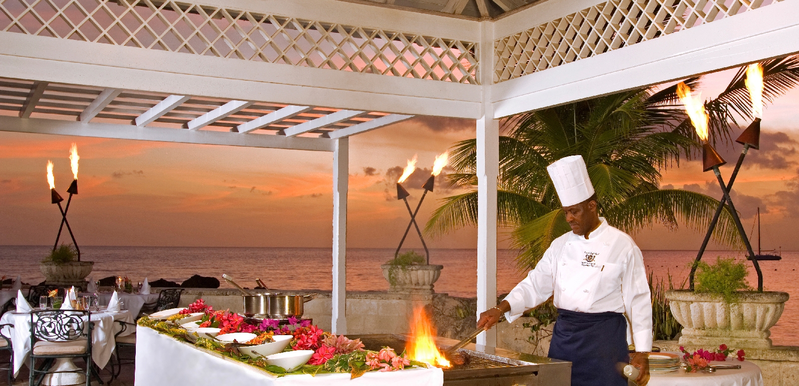 a chef cooking at during sunset at coral reef club, barbados