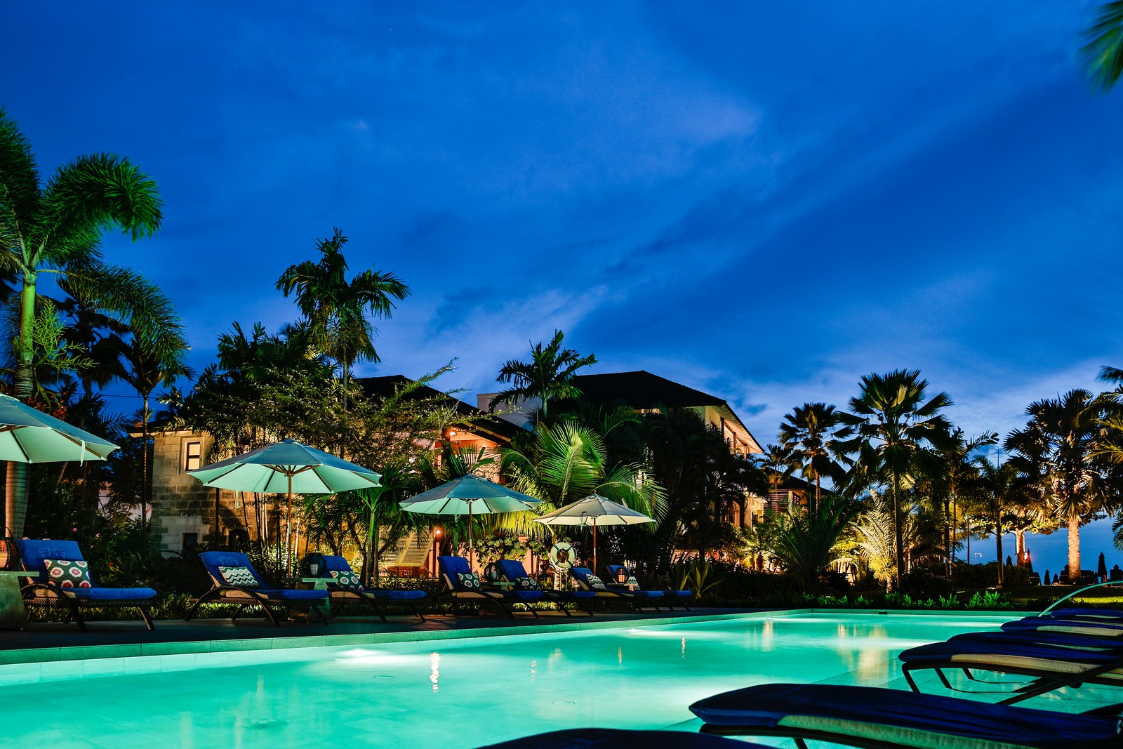 Swimming pool and sunloungers at night of the Sandpiper, Barbados