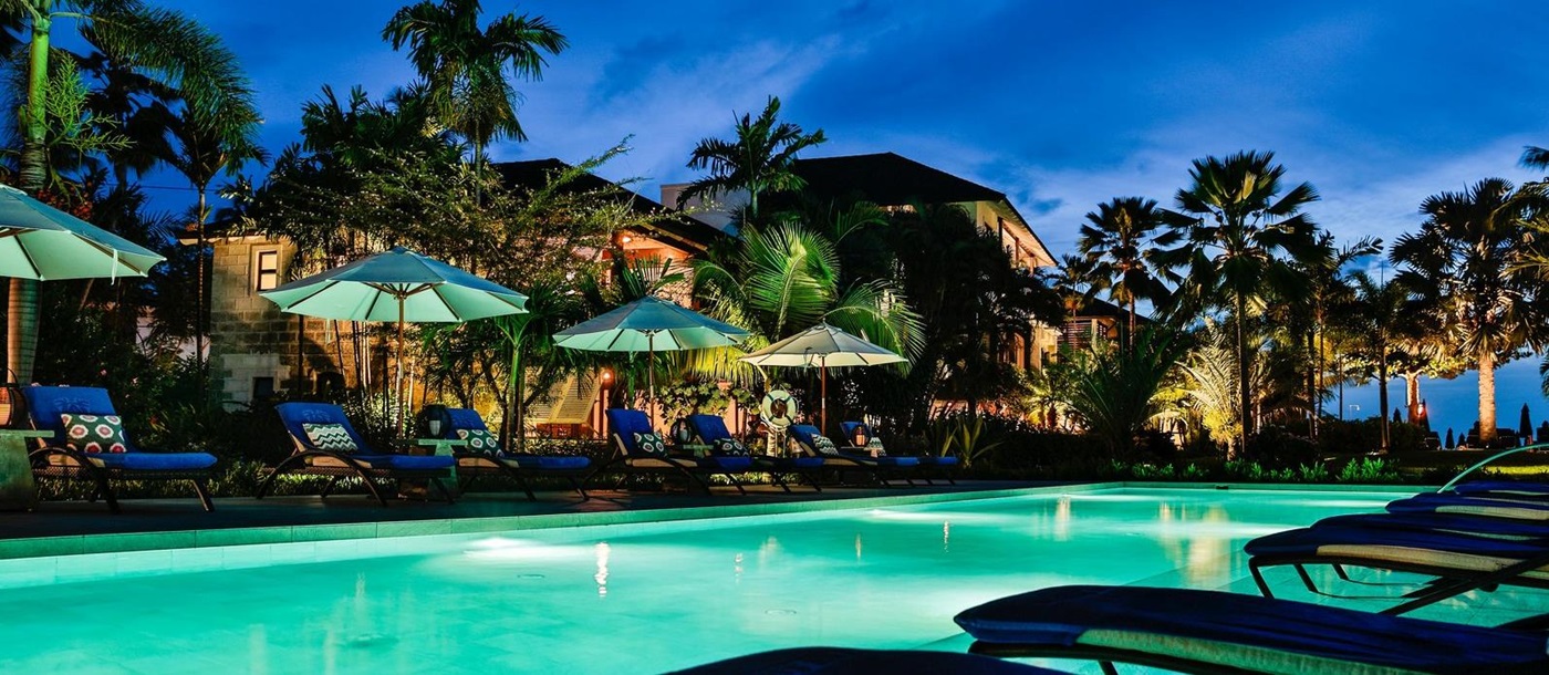 Swimming pool and sunloungers at night of the Sandpiper, Barbados