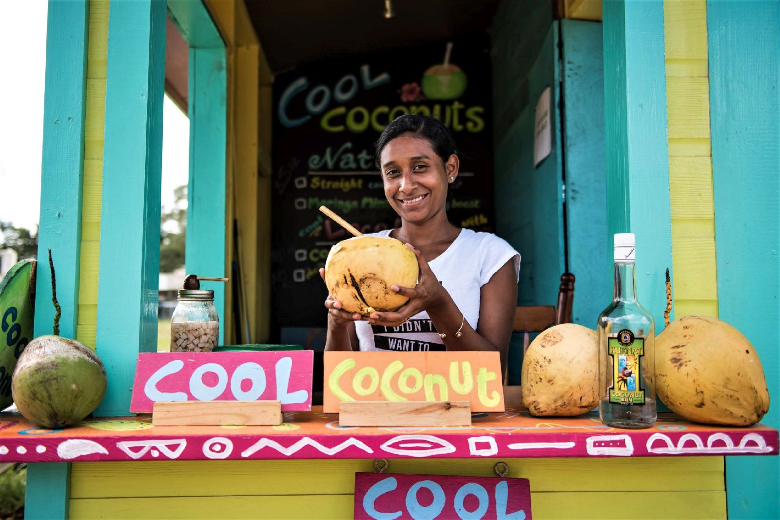 Smiling girl at a coconut stall in Placencia, Belize