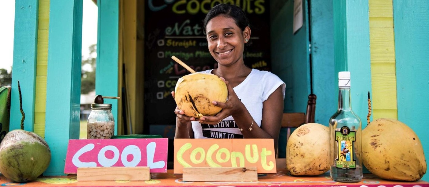 Smiling girl at coconut stall in Placencia Belize