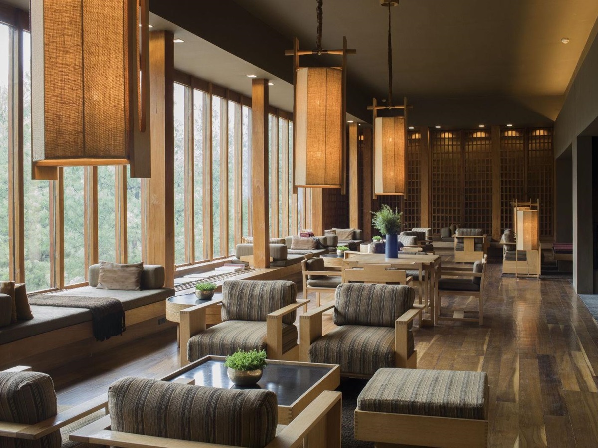 Comforting lounge area with floor to ceiling windows and indoor fireplace at luxury hotel Amankora Paro in Bhutan